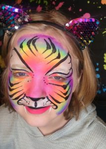 Girl's face painted like a tiger