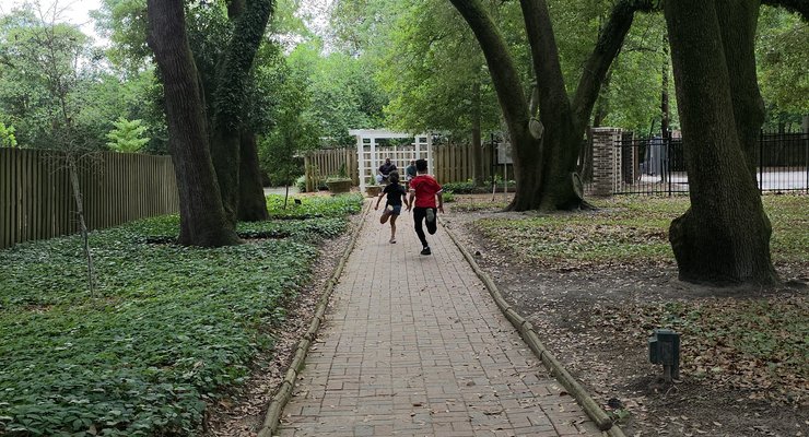 Family exploring the shaded pathways at Hopelands Gardens in Aiken, SC