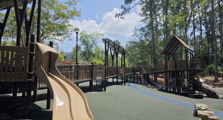 Playground with slides and soft padded ground surrounded by trees at Virginia Hylton Park in Lexington SC