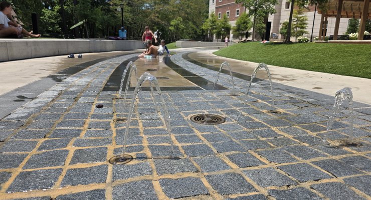 Splash pad with water jets and families enjoying the long narrow water feature at Virginia Hylton Park in Lexington SC