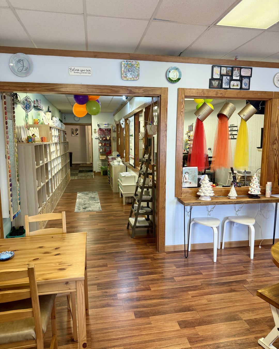 Inside Dodo N Jeans pottery studio in Camden SC with shelves of unglazed pottery pieces and painting tables