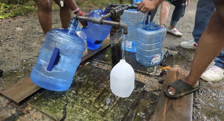 Visitors filling large water jugs at the spigots at God's Acre Healing Springs in Blackville, SC