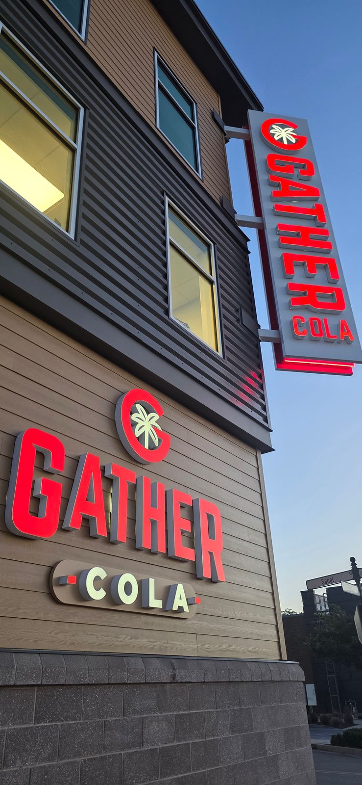 The Gather COLA sign lit up on the building exterior at dusk in Columbia's BullStreet District