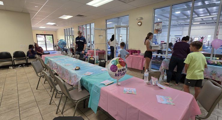 Birthday party tables set up with pink and blue tablecloths at Lake Murray Gymnastics